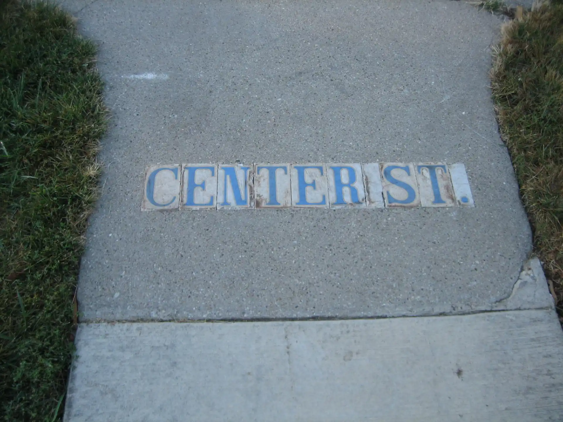 Decorative tile street marker embedded in sidewalk along Center Street in downtown Yorkville, Illinois